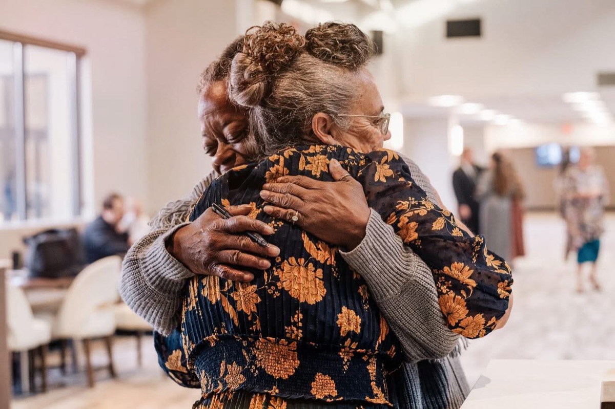 Two women embracing after a service at New Life