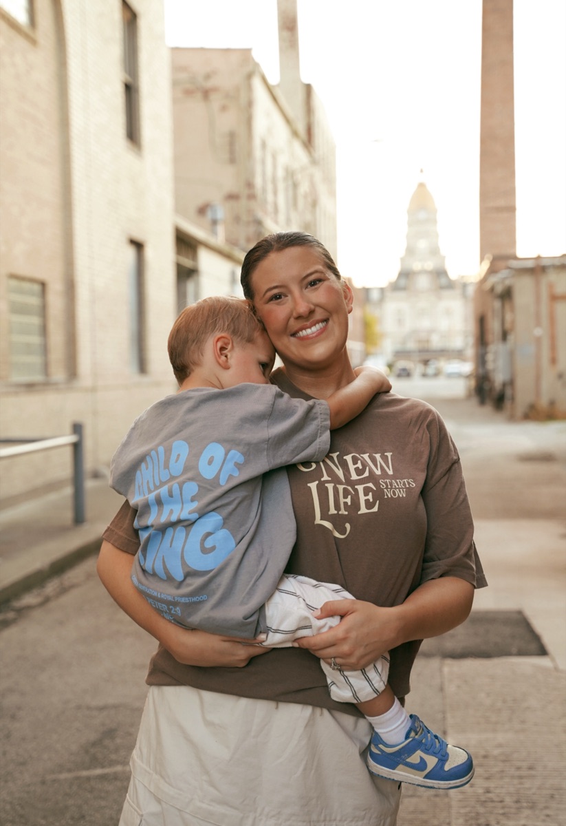 A mom holding her toddler on a downtown Terre Haute street
