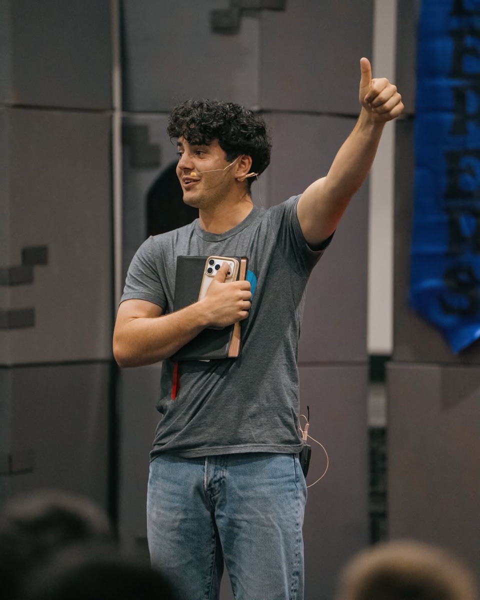 A kids teacher mid-lesson, mic on and thumb raised